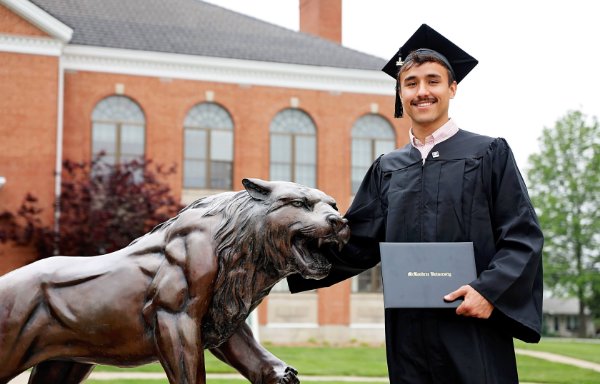 Student in mortarboard with diploma at graduation