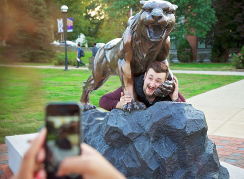 Student Taking a Photo Bearcat Statue